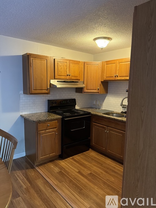 A kitchen with wooden cabinets and a black stove top oven.