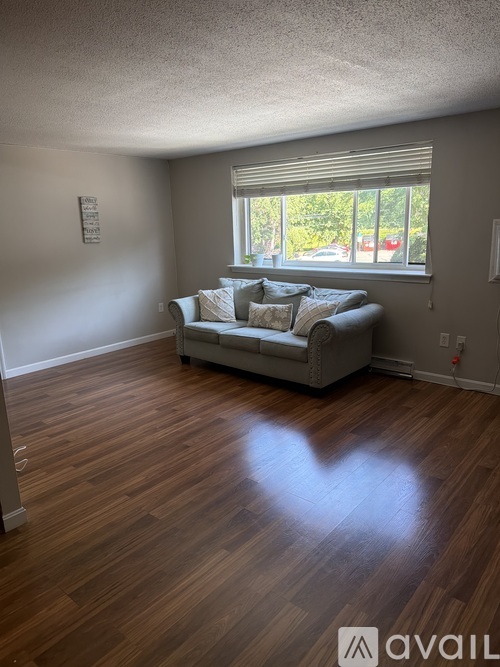 A living room with a couch and a window.