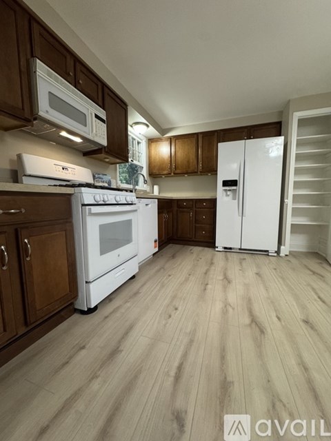 A kitchen with wooden cabinets and a white fridge.