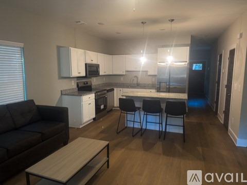 A modern kitchen with white cabinets and a black couch.
