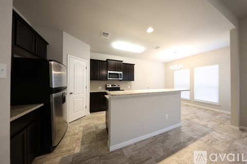 A kitchen with a refrigerator, microwave, and oven is available for rent.