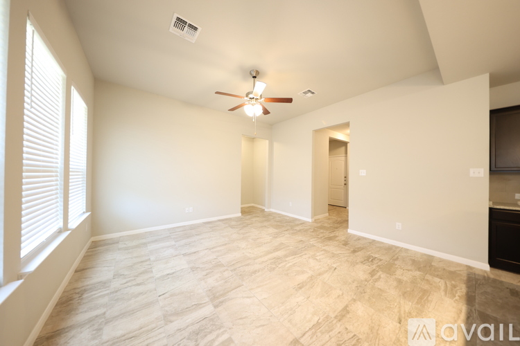 A spacious room with a ceiling fan and light fixture.