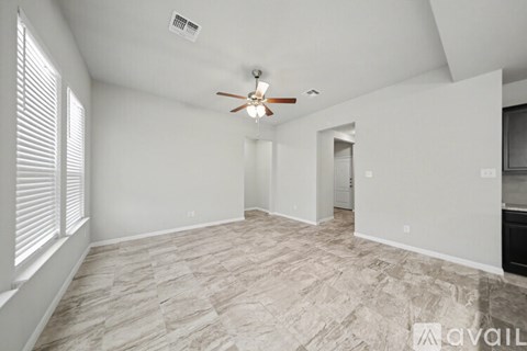 A spacious room with a ceiling fan and light fixture.