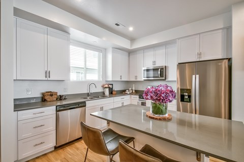 A kitchen with white cabinets and a granite countertop.