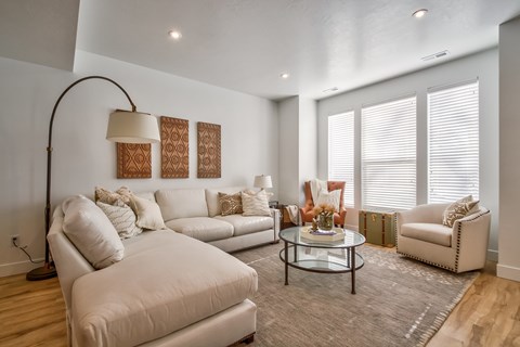 A living room with a white couch, a glass table, and a floor lamp.