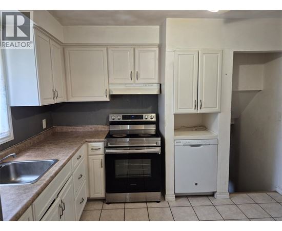A kitchen with white cabinets and a black stove top oven.