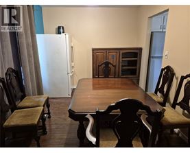 A dining room with a wooden table and chairs.