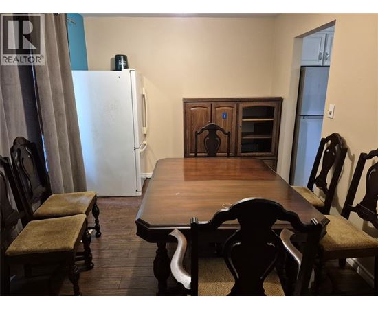 A dining room with a wooden table and chairs.