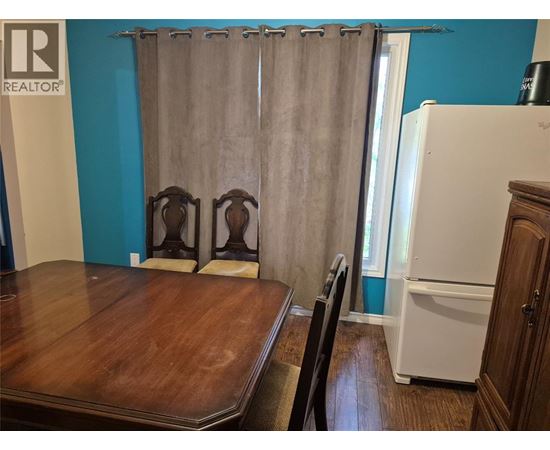 A kitchen with a white refrigerator and a wooden table.