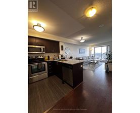 A kitchen with dark wood floors and stainless steel appliances.