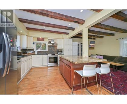 A kitchen with a refrigerator on the left and a table with two chairs in the middle.