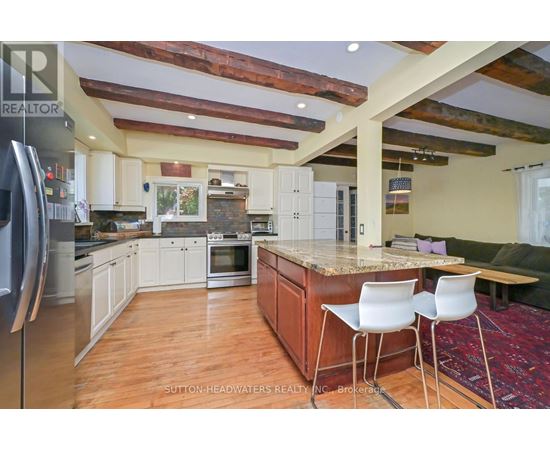 A kitchen with a refrigerator on the left and a table with two chairs in the middle.