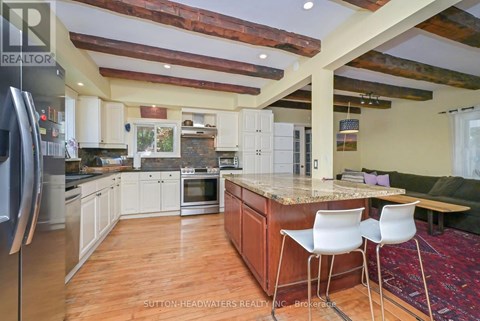 A kitchen with a refrigerator on the left and a table with two chairs in the middle.