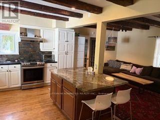 A kitchen with a large island and a couch in the living room.