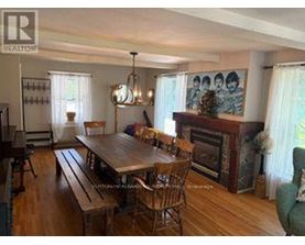 A dining room with a wooden table and chairs.