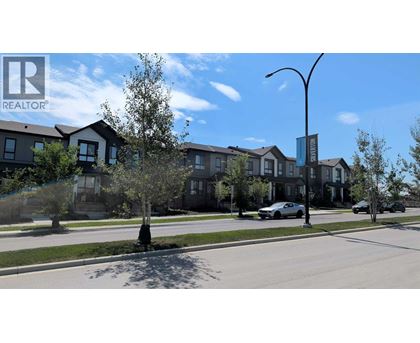 A row of houses with a car parked in front of one.