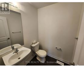 A bathroom with a sink, toilet, and mirror.