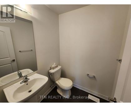 A bathroom with a sink, toilet, and mirror.