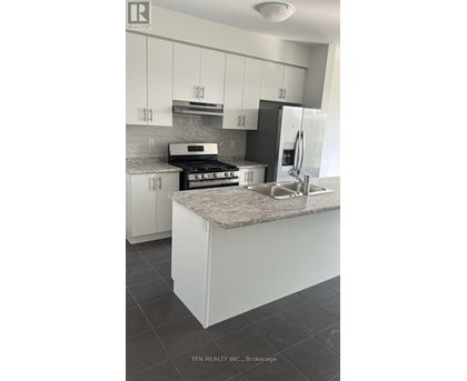 A kitchen with white cabinets and a granite countertop.