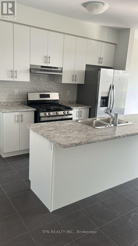 A kitchen with white cabinets and a granite countertop.