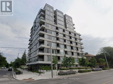 A tall residential building with balconies on the upper floors.