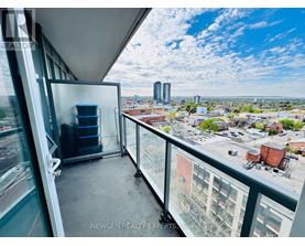 A balcony with a chair and a table overlooking a cityscape.