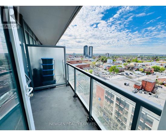A balcony with a chair and a table overlooking a cityscape.