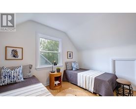 A bedroom with two beds and a window.