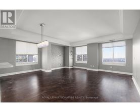 A spacious room with wooden flooring and a large window.
