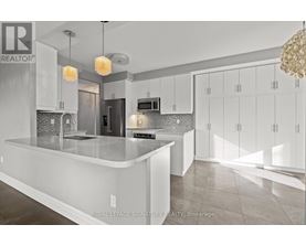 A modern kitchen with white cabinets and a central island.
