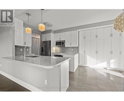 A modern kitchen with white cabinets and a central island.