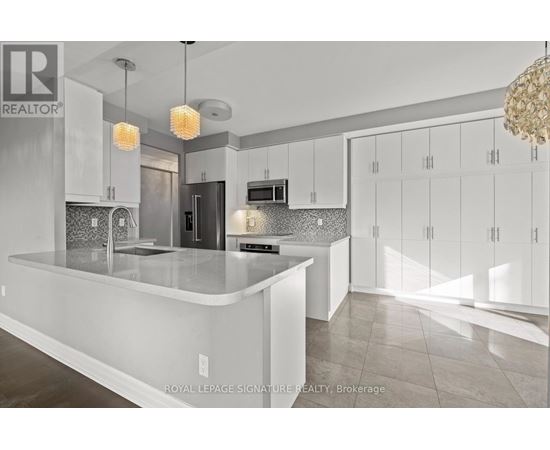 A modern kitchen with white cabinets and a central island.