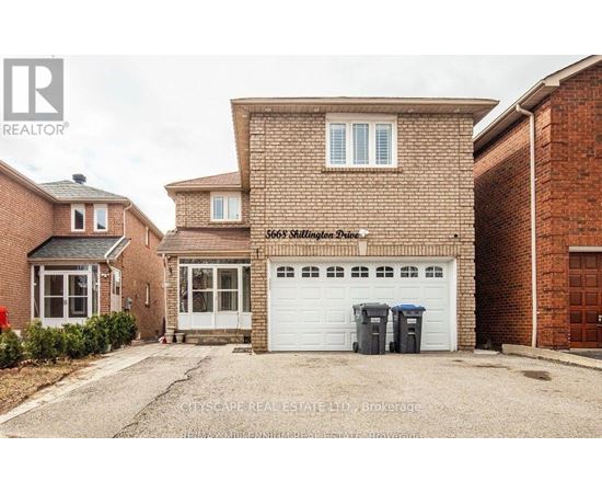 A brick house with a white garage door is for sale.