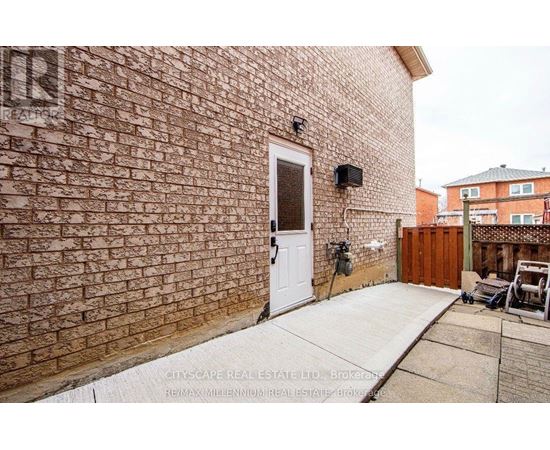 A brick wall with a white door and a small window above it.
