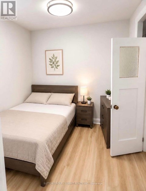 A bedroom with a bed, nightstand, and a door.