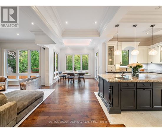A spacious kitchen and dining area with dark wood floors and white walls.