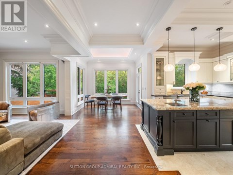 A spacious kitchen and dining area with dark wood floors and white walls.