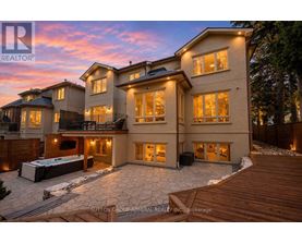 A large, luxurious house with a hot tub in the backyard.