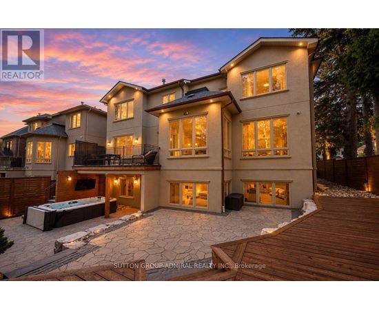 A large, luxurious house with a hot tub in the backyard.