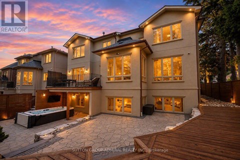 A large, luxurious house with a hot tub in the backyard.
