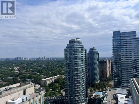 A cityscape with a tall building in the foreground and other buildings in the background.