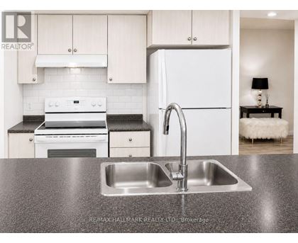A modern kitchen with a sink and a refrigerator.