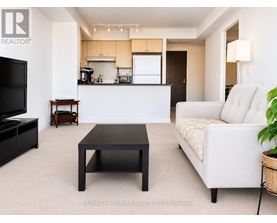 A living room with a white couch and a black coffee table.