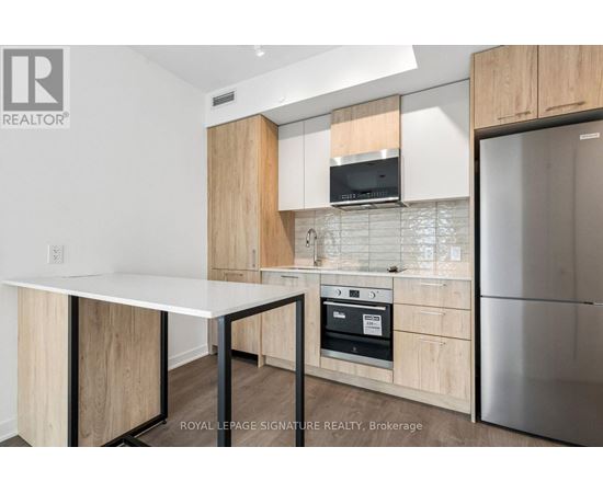 A kitchen with a white table and wooden cabinets.