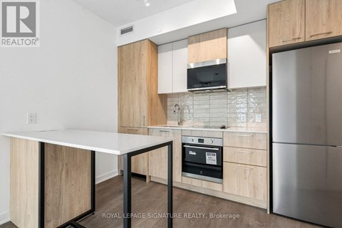 A kitchen with a white table and wooden cabinets.