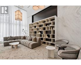 A modern living room with a grey sofa, a white coffee table, and a wall with a shelf.