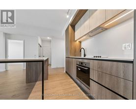 A modern kitchen with wooden cabinets and a stainless steel oven.