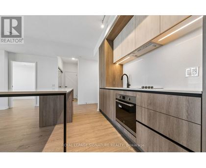 A modern kitchen with wooden cabinets and a stainless steel oven.