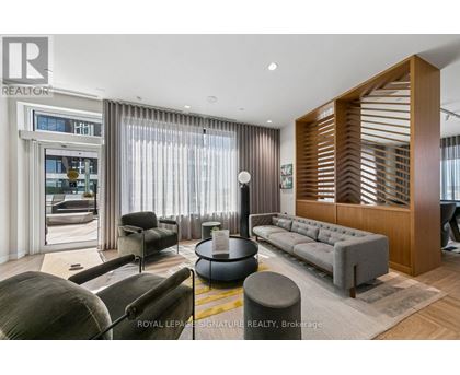 A living room with a grey sofa and a wooden slatted wall.