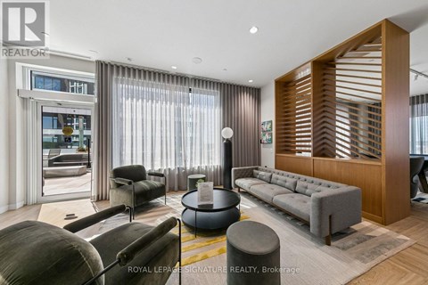 A living room with a grey sofa and a wooden slatted wall.